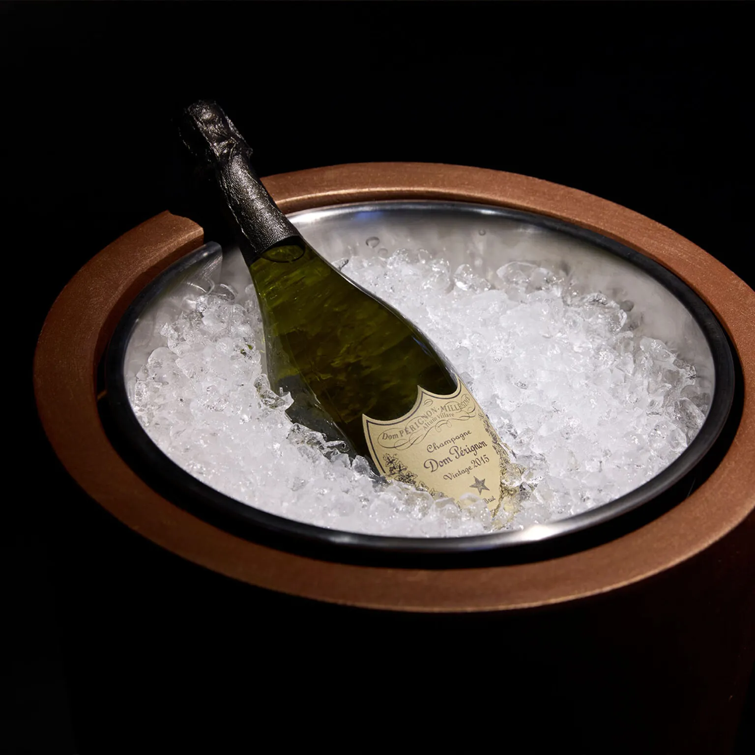 Ein Champagne Dom Pérignon in einem edlen Eimer aus Holz, gefüllt mit Eiswürfeln.